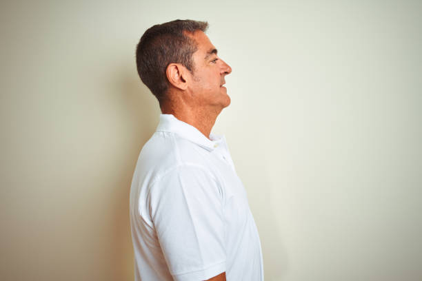 istock Handsome middle age man wearing polo standing over isolated white background looking to side, relax profile pose with natural face with confident smile. 1213971420