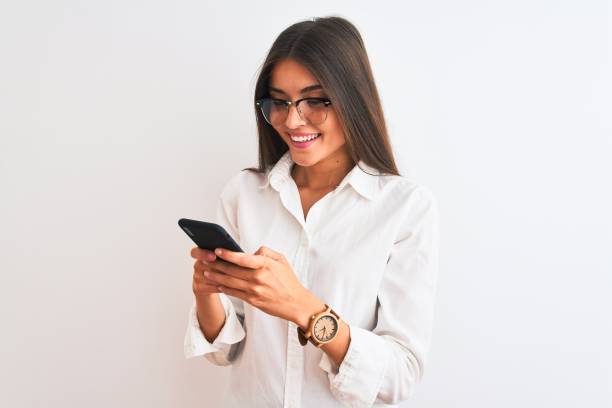 schöne geschäftsfrau trägt brille mit smartphone über isolierten weißen hintergrund mit einem glücklichen gesicht stehen und lächelnd mit einem selbstbewussten lächeln zeigt zähne - toothy smile relaxation white healthcare and medicine stock-fotos und bilder