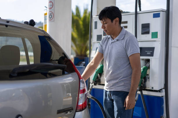 istock Young man working at a gas station refueling a customer's car 1213980319
