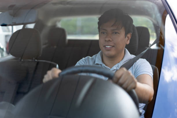 istock Cheerful young man driving his car 1213980520