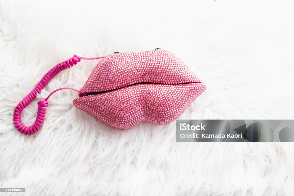 pink sequin lip shape telephone with fluffy white background 80s retro style old fashion Retro pink phone. Telephone Stock Photo