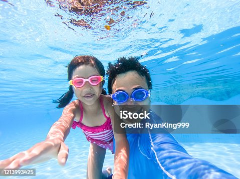 istock asian family in swimming pool 1213993425