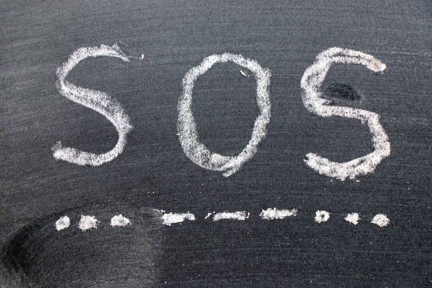 istock White color chalk hand drawing in SOS (abbreviation of save our soul/ship or sibling over shoulder) on black board background 1213996994