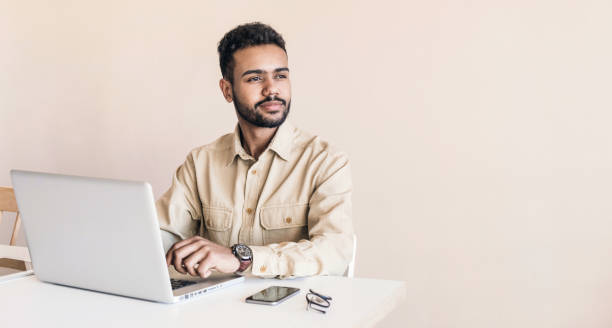 istock Cheerful man using laptop working at home online 1214001382