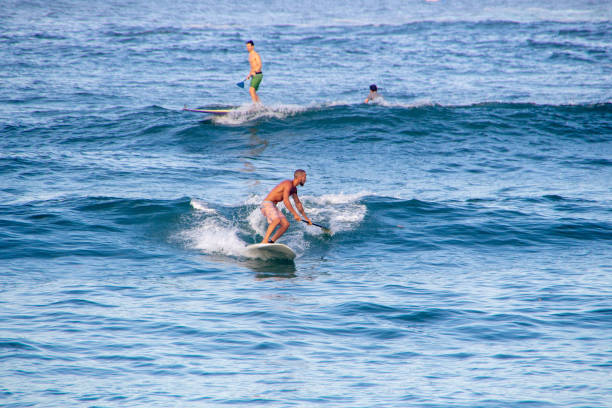 Man practicing stand up paddle at Copacabana beach in Rio de Janeiro, Brazil - March 7, 2020: Man practicing stand up paddle at post six on Copacabana beach in Rio de Janeiro.