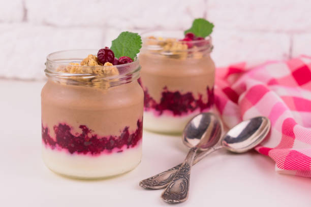 istock Two  chocolate-vanilla pudding with berries and a jar on a white background. 1214005198