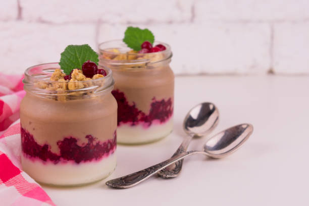 istock Two  chocolate-vanilla pudding with berries and a jar on a white background. 1214005979