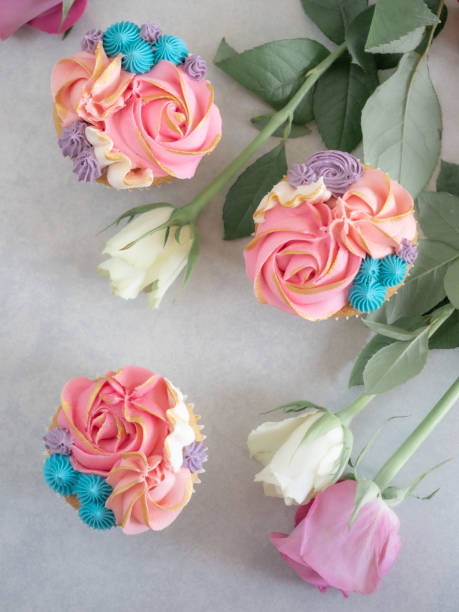 istock Top down view of three cupcakes among some roses 1214010723