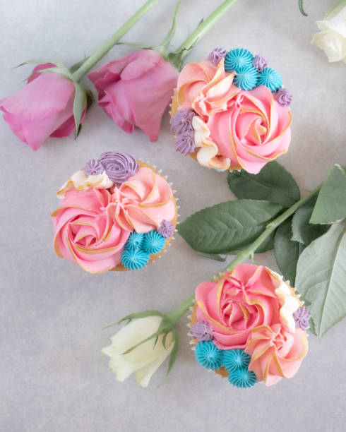 istock Top down view of three cupcakes among some roses 1214010731