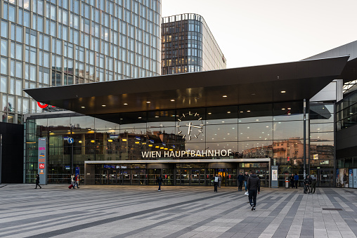Vienna, Austria - April 17, 2019: The main entrance to the Wien Hauptbahnhof (Hbf), the main railway station of Vienna, opened in 2015, with the modern glass facade and a large clock.