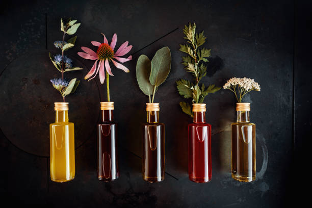 various herbal oils with flowers - aromatic oil imagens e fotografias de stock