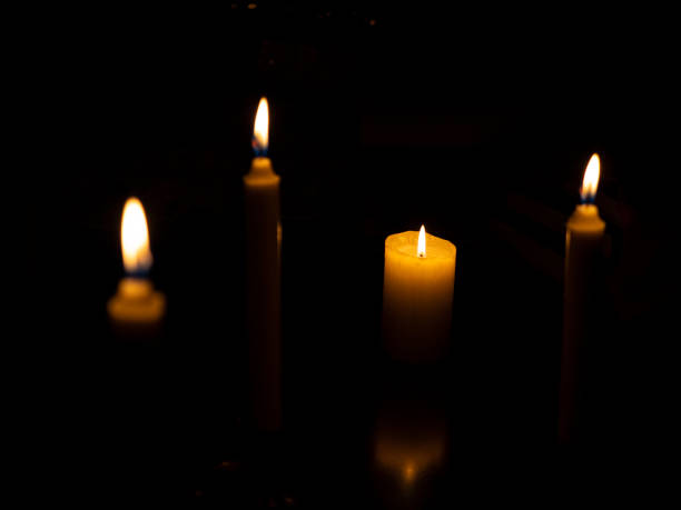 istock Burning candles of different sizes with some reflection 1214015556