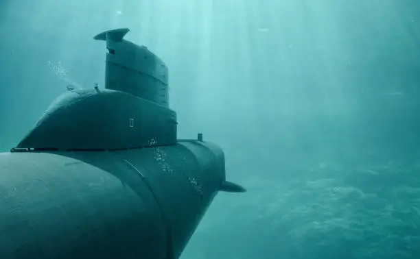 A submarine dives in the sea through clear water.