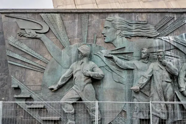 Bas-relief with soviet cosmonaut and scientists carved on the monument to the Conquerors of Space at the All-Russian Exhibition Center. Shooting at a winter on day, front view