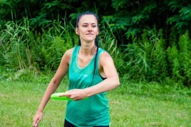 istock Woman playing with flying disc in the park 1214019080