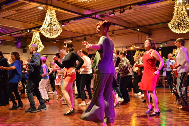 Workshop classes. Indoor line dancing by a professional instructor. Herent, Belgium - September 14, 2019: Open House indoor dancing classes evening show. Photo reportage open door promotion indoor dance classes. Courses starting half September. Teacher Sandrine (hair in a dot) in front of group demonstrates solo line dance. teacher retirement party stock pictures, royalty-free photos & images