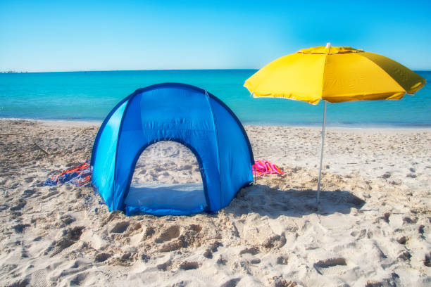 istock Camping tent and beach umbrella by the sea 1214019897
