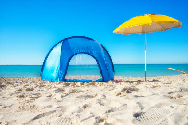 istock Camping tent and beach umbrella by the sea 1214019917
