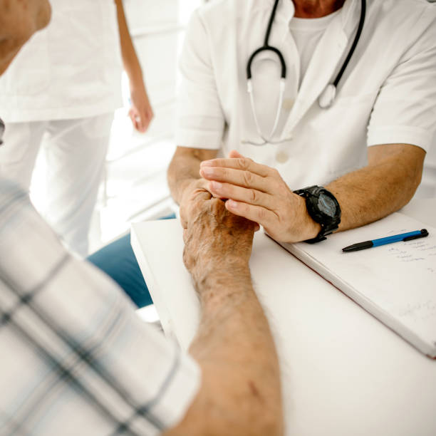 istock Doctor holding an old man's hand 1214023249