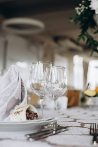 istock Server table plate knife fork and wine glasses at the banquet. Luxurious elegant dinner at the table in the restaurant. Holiday table decoration 1214023961