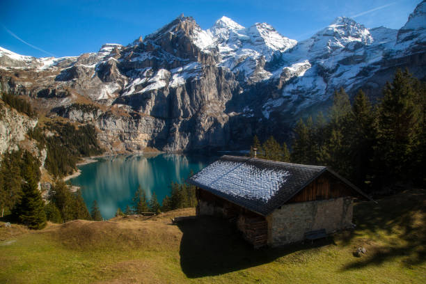 Idyllic winter scene with wooden mountain hut on a ski slope.