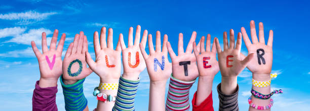 istock Children Hands Building Word Volunteer, Blue Sky 1214026912