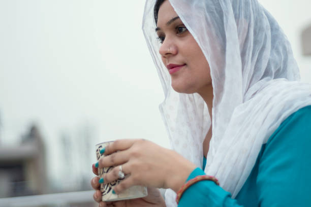 istock Beautiful woman is drinking coffee on the home rooftop 1214027899