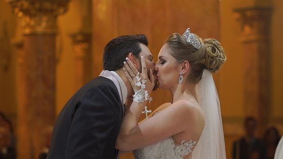 Bride and groom kissing after wedding ceremony on church