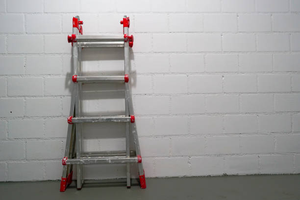 aluminum metal ladder with old paint in a simple cellar room with gray floor and white brick wall - cave painting imagens e fotografias de stock