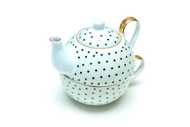 The modern but retro or vintage looking set of dotted tea kettle with a tea cup isolated in a white background.