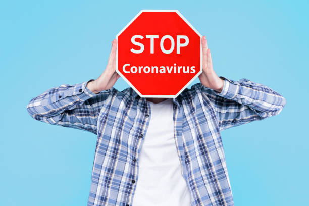 istock Yound man holding stop sign. Stop coronavirus COVID-19 concept 1214032144