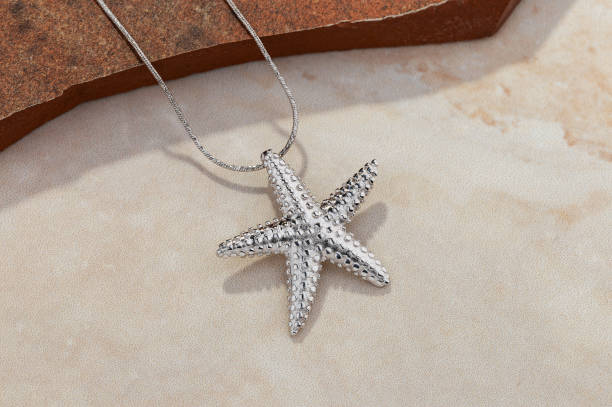 istock Starfish shape silver pendant necklace on beige background 1214035079