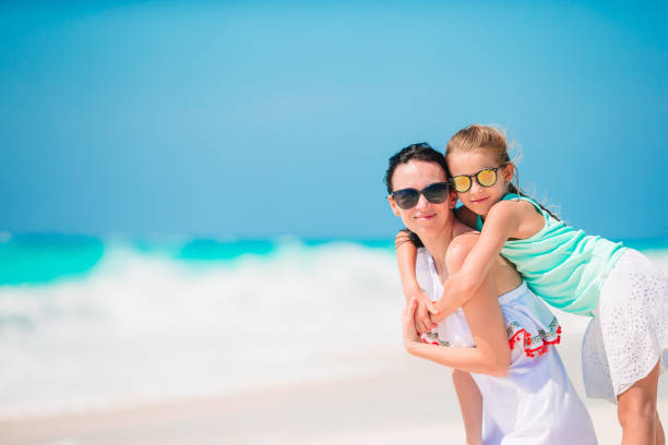 istock Beautiful mother and daughter on the beach 1214040731