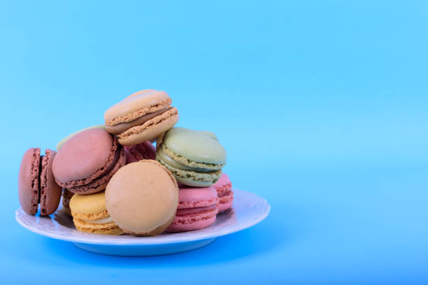istock Colorful macaroons cake, sweet macaroon on blue background, food background 1214040965