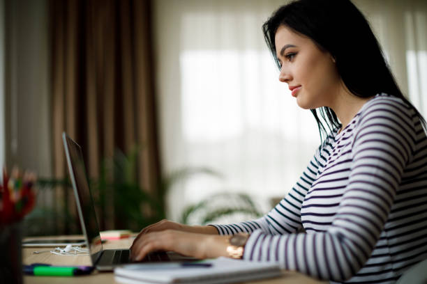 istock Woman using laptop at home 1214046429