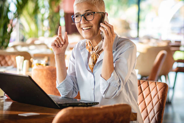 istock Senior woman using laptop in a coffee shop 1214047113