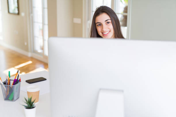 istock Beautiful young business woman working using computer, smiling and concentrated on online work 1214050987