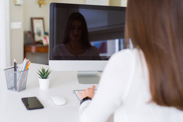 istock Young woman smiling working using computer and showing a blank screen on the background 1214051014