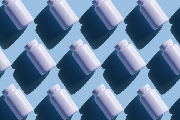 istock Repeating white cans of pills on a blue background 1214051076