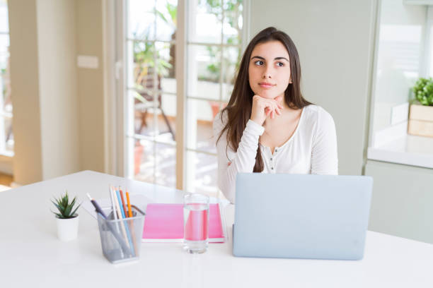 istock Beautiful young student woman studying for university using laptop and notebook serious face thinking about question, very confused idea 1214051133