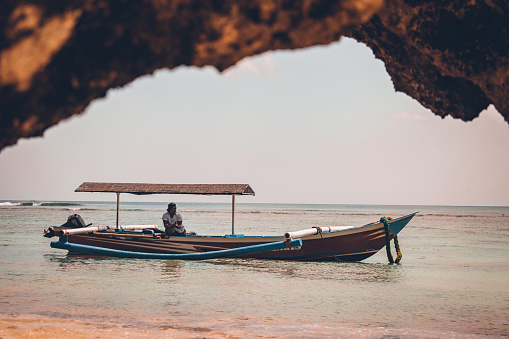 Fisherman and boat in the sea