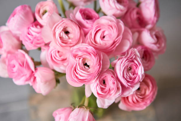 istock Spring background, flower Wallpaper. Persian buttercup. Bunch pink ranunculus flowers on light gray background. Vase on vintage wooden table. Wallpaper 1214052530