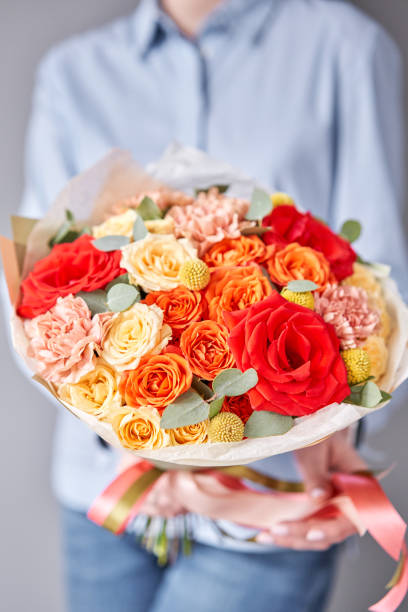 European floral shop. Beautiful bouquet of mixed flowers in woman hands. Work of the florist at a flower shop. Delivery fresh cut flower. European floral shop. Two Beautiful bouquets of mixed flowers in womans hands. the work of the florist at a flower shop. Delivery fresh cut flower weed delivery holland stock pictures, royalty-free photos & images