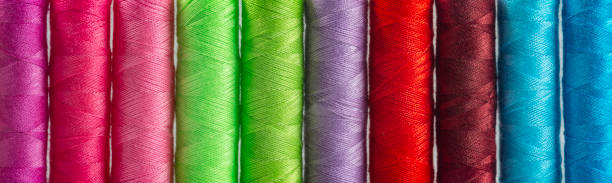 Panoramic detail view of differently colored spools of thread Panoramic detail view of differently colored spools of thread Fluoroplastic Fabrics stock pictures, royalty-free photos & images