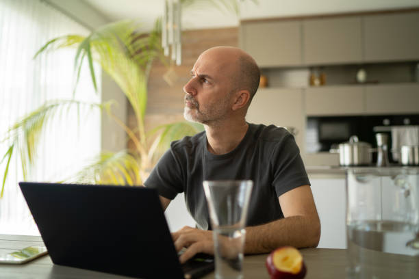 istock one mature adult thoughful looking man working from home during coronavirus quarantine 1214053403