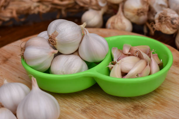 istock Garlic Cloves and Bulb on wooden cutting board 1214055518