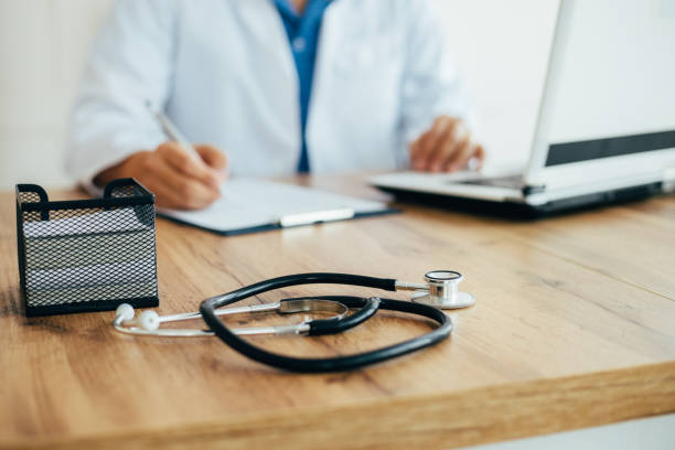 istock Doctor in uniform working on laptop at clinic 1214056713