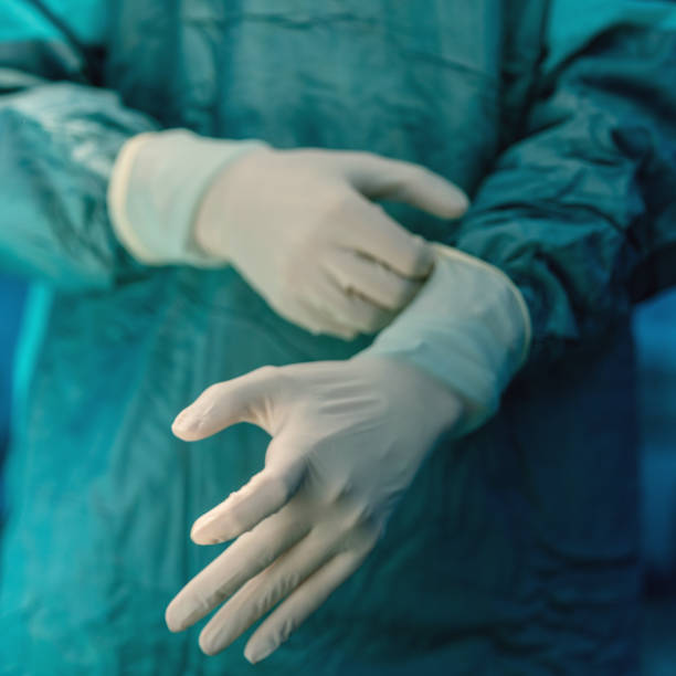 istock Doctor hands pulling on surgical gloves in hospital 1214057078