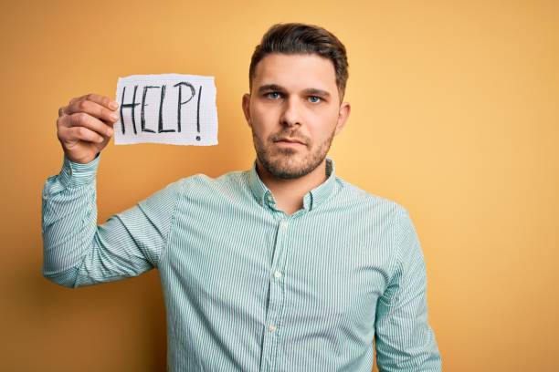 istock Young business man with blue eyes asking for help holding paper note over yellow background with a confident expression on smart face thinking serious 1214058019