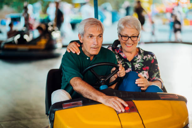 istock Excited seniors having fun riding bumper car 1214058039
